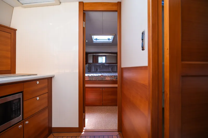 Slide: The Image of Interior view of 2017 Palm Beach Motor Yachts PB42, featuring wood cabinetry and cozy bedroom. - 44