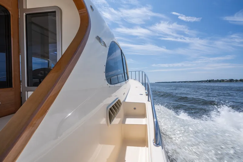 Slide: The Image of 2017 Palm Beach Motor Yachts PB42 cruising on open water under a clear blue sky. - 20
