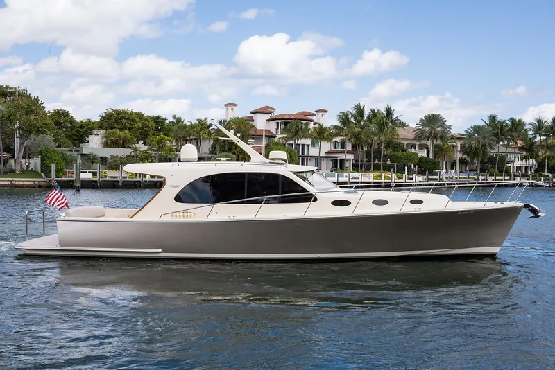 Slide: The Image of 2017 Palm Beach Motor Yachts PB42 cruising on a scenic waterway with luxury homes in the background. - 57