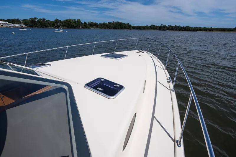 Slide: The Image of 2017 Palm Beach Motor Yachts PB42 cruising on a serene lake under a clear blue sky. - 23