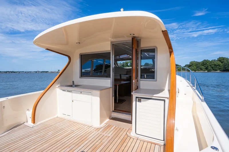Slide: The Image of 2017 Palm Beach Motor Yachts PB42, elegant deck view with open cabin, on serene water. - 13