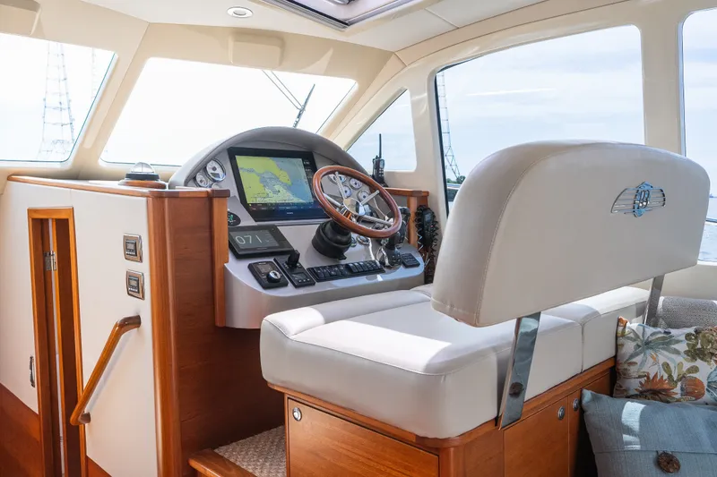Slide: The Image of Helm of 2017 Palm Beach Motor Yachts PB42 with navigation controls and plush seating. - 4