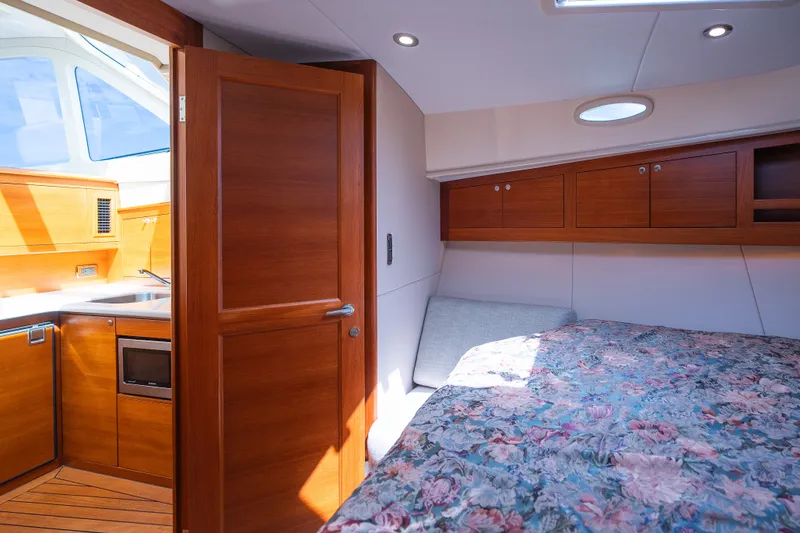Slide: The Image of Luxurious 2017 Palm Beach Motor Yachts PB42 cabin interior with wood finishes and floral bedding. - 45