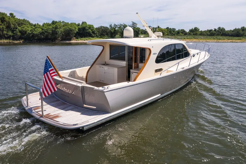 Slide: The Image of 2017 Palm Beach Motor Yachts PB42 cruising on a serene lake with lush greenery. - 7