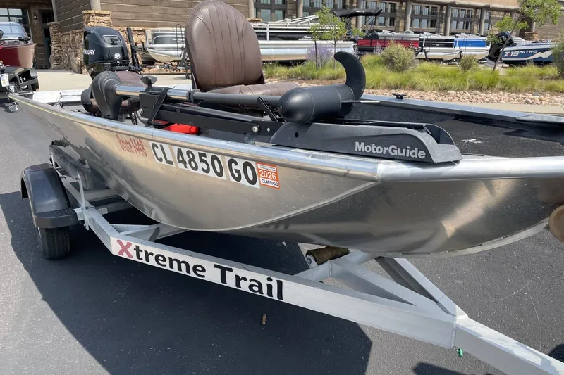 Slide: The Image of 2014 Extreme Boats Brute 1448T on trailer with MotorGuide motor, parked outdoors. - 5