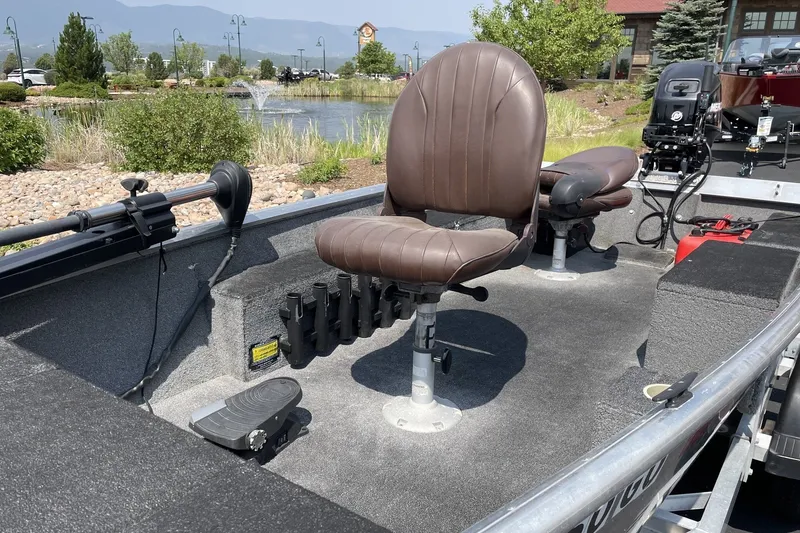 Slide: The Image of 2014 Extreme Boats Brute 1448T interior with brown seats and fishing rod holders. - 2