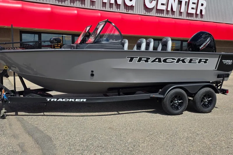 The Image of 2027 Tracker Targa V-18 WT boat on trailer, parked outside a building with red awning. - 1