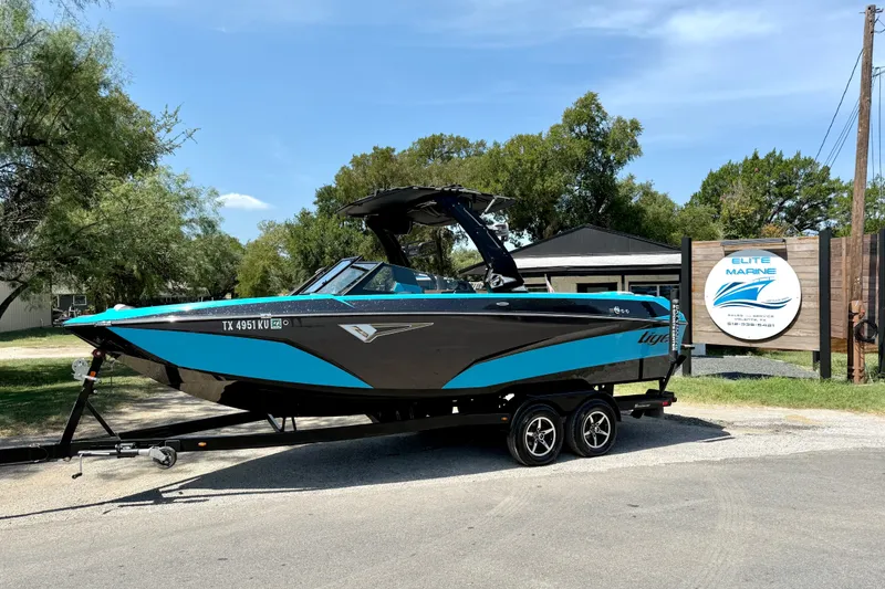 Slide: The Image of 2023 Tige Z3 boat in blue and black, parked at Elite Marine dealership. - 1