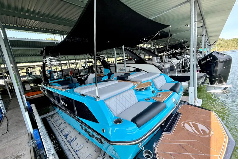 Slide: The Image of 2023 Tige Z3 boat docked in a marina, showcasing sleek design and vibrant blue color. - 26