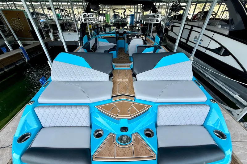 Slide: The Image of 2023 Tige Z3 boat interior with blue and gray seating, docked in a marina. - 27