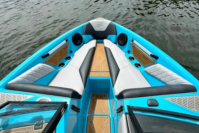 Slide: The Image of 2023 Tige Z3 boat interior with blue and white seating, wood accents, and cup holders. - 17