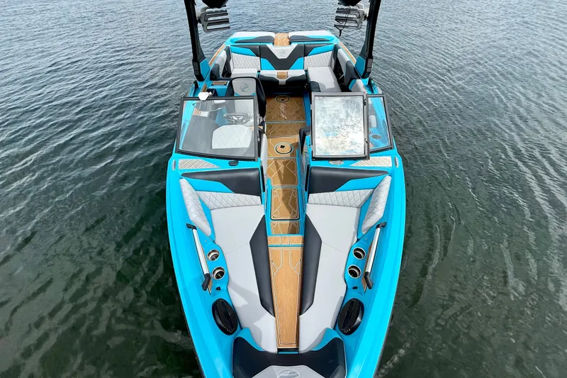 Slide: The Image of 2023 Tige Z3 boat with sleek blue design and luxurious seating on calm water. - 16