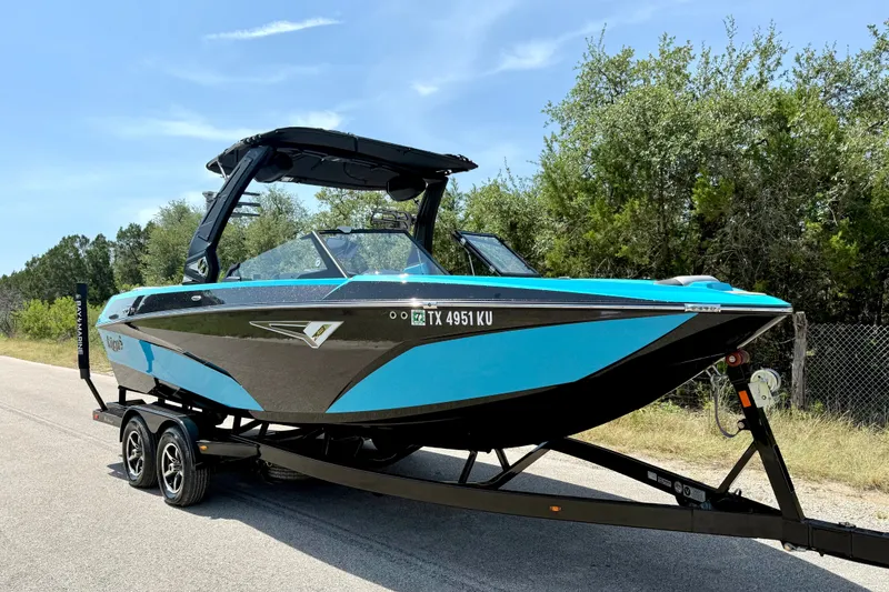 Slide: The Image of 2023 Tige Z3 boat on trailer, vibrant blue and black design, parked on roadside. - 13