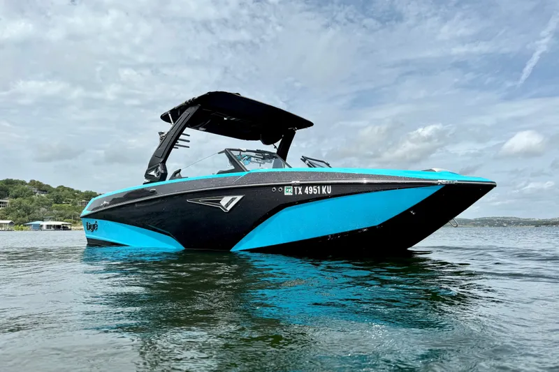 Slide: The Image of 2023 Tige Z3 boat on water, featuring sleek black and blue design under a cloudy sky. - 7