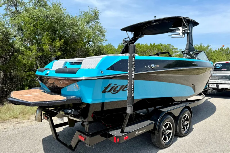 Slide: The Image of 2023 Tige Z3 boat on trailer, vibrant blue, sleek design, parked outdoors. - 11