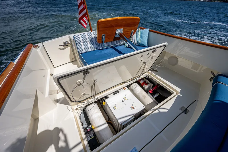Slide: The Image of 2020 Hinckley Picnic Boat 40 with open engine compartment, American flag, and blue seating. - 28