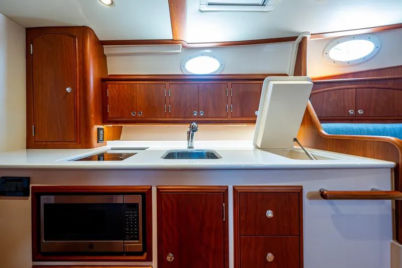 Slide: The Image of Luxurious 2020 Hinckley Picnic Boat 40 interior kitchen with wood cabinetry and modern appliances. - 23