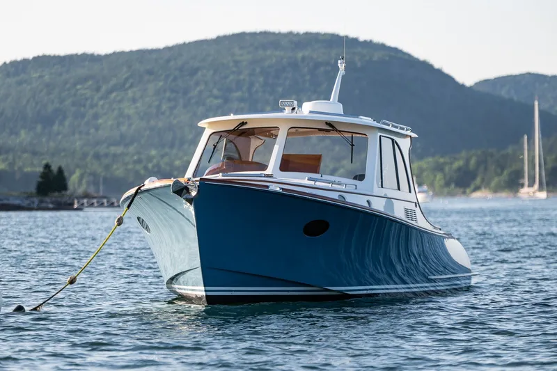 Slide: The Image of 2020 Hinckley Picnic Boat 40 on serene water with scenic mountain backdrop. - 33