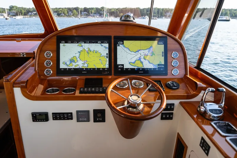 Slide: The Image of Helm of 2020 Hinckley Picnic Boat 40 with navigation screens and wooden steering wheel. - 19