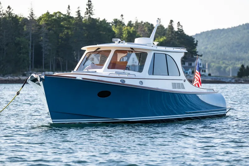 The Image of 2020 Hinckley Picnic Boat 40 cruising on serene waters with forested backdrop. - 1