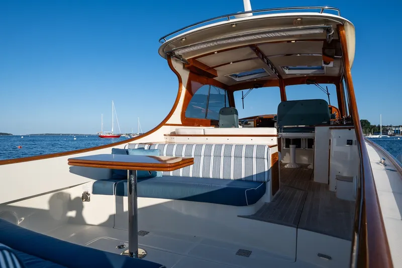 Slide: The Image of 2020 Hinckley Picnic Boat 40 interior with seating and table, overlooking a serene ocean view. - 16