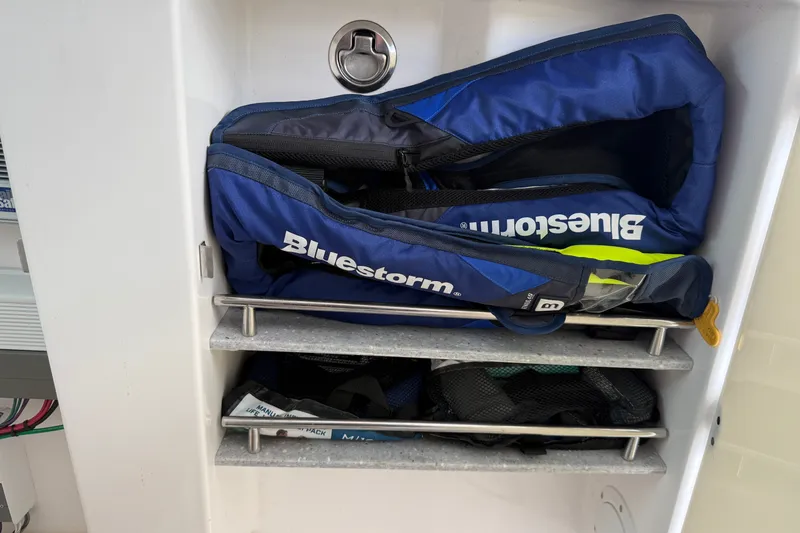 Slide: The Image of Storage compartment with Bluestorm life jackets on Everglades 365 Center Console, 2022 model. - 38