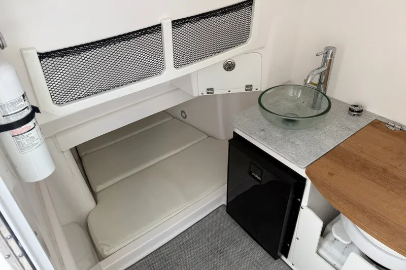 Slide: The Image of Interior of 2022 Everglades 365 Center Console with sink, fridge, and cushioned seating. - 36
