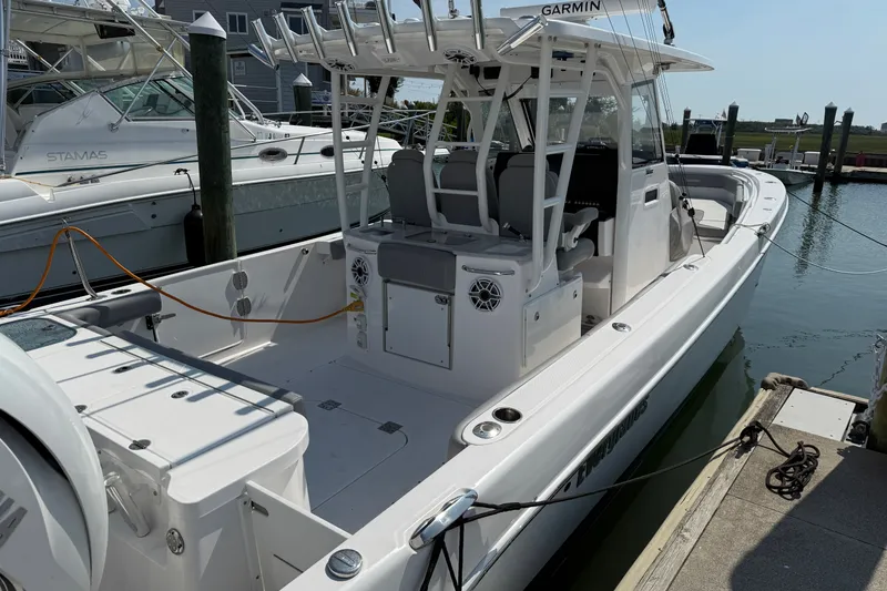 Slide: The Image of 2022 Everglades 365 Center Console boat docked at marina, featuring spacious deck and modern design. - 44
