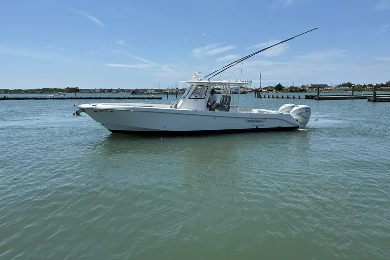 The Image of 2022 Everglades 365 Center Console boat cruising on calm waters under clear skies. - 0