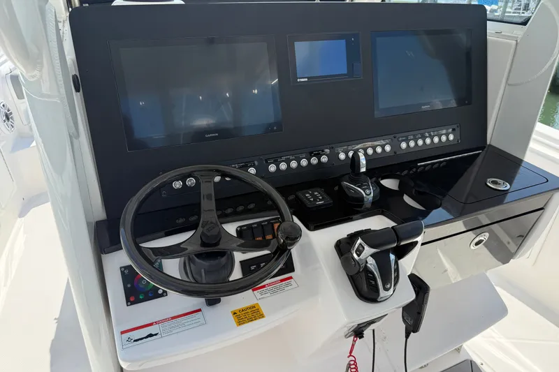 Slide: The Image of 2022 Everglades 365 Center Console boat dashboard with steering wheel and electronic controls. - 18