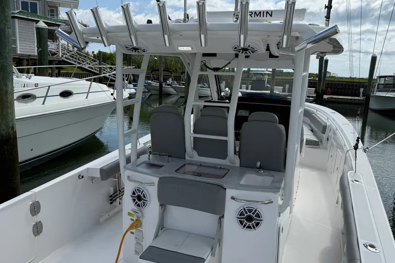 Slide: The Image of 2022 Everglades 365 Center Console boat docked, featuring spacious seating and modern amenities. - 34
