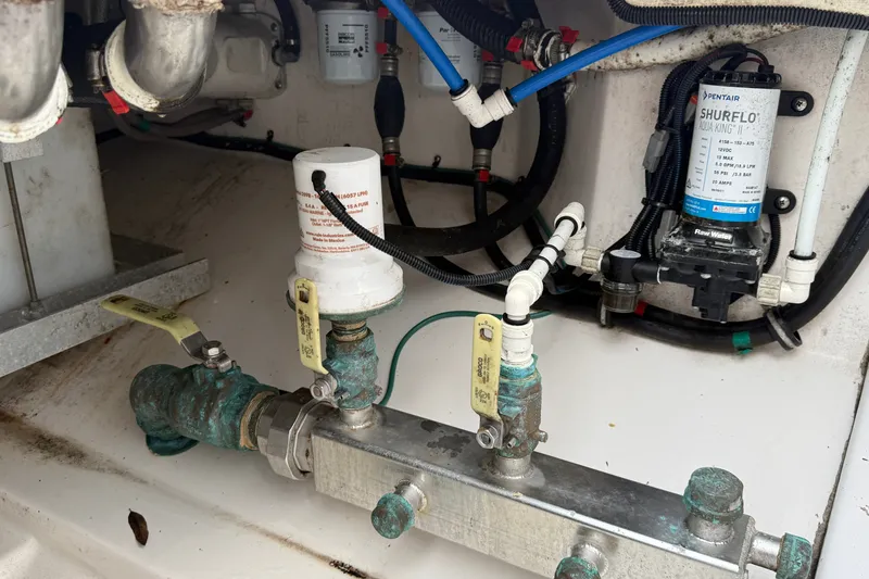 Slide: The Image of Engine compartment of 2022 Everglades 365 Center Console with plumbing and filtration system. - 50