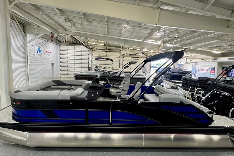 Slide: The Image of 2026 Bennington 23 M Center Swingback pontoon boat in showroom, featuring sleek design and modern seating. - 22
