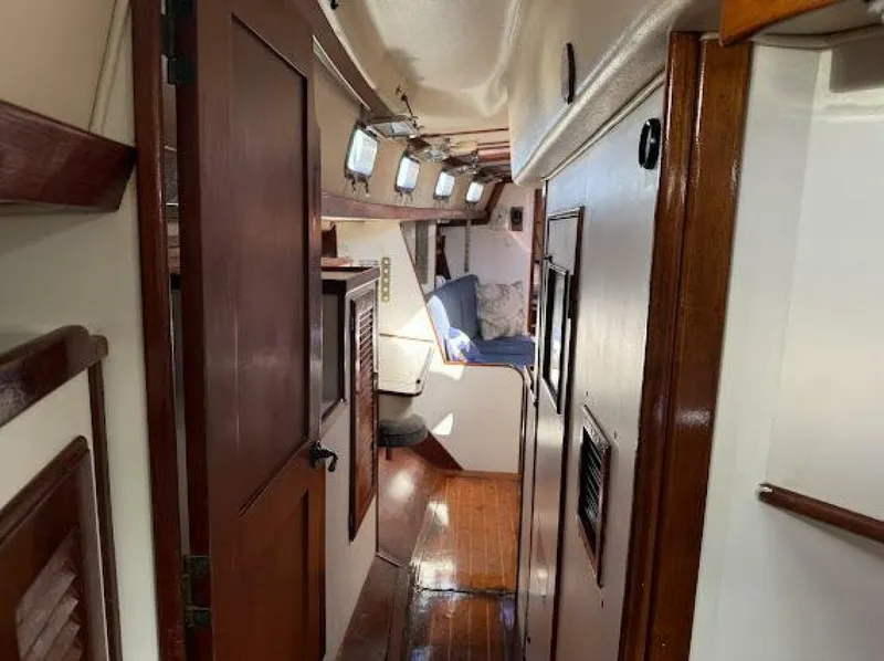 Slide: The Image of Interior view of a sailboat with wooden floors and white walls, featuring a cozy living area. - 22