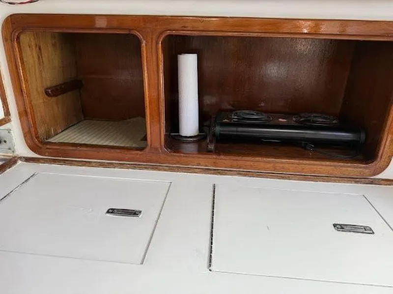 Slide: The Image of An open wooden shelf with two compartments, one empty, the other with a paper roll and black object. - 45