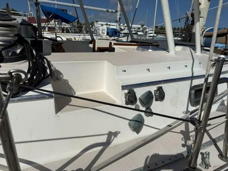 Slide: The Image of The deck of a sailboat with ropes and fittings, surrounded by other boats in a marina. - 2