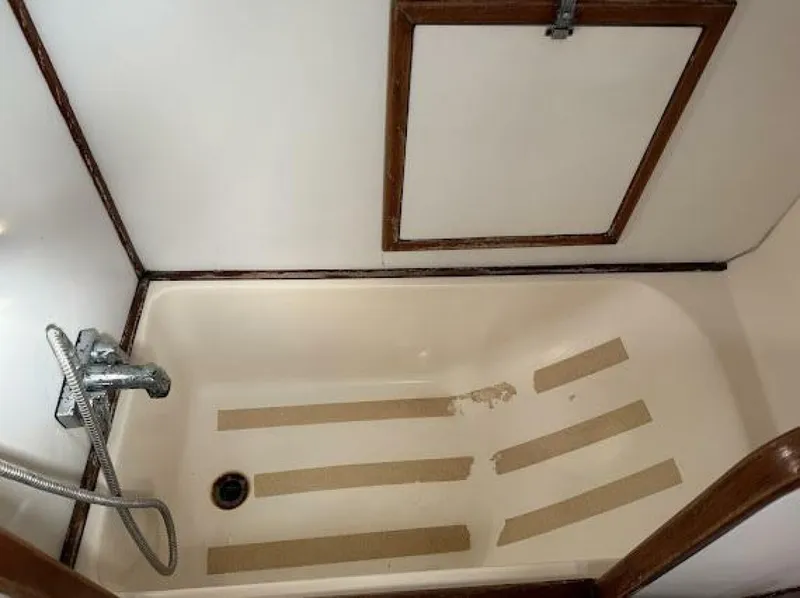 Slide: The Image of A simple boat bathroom with a shower tray and a handheld showerhead. - 25