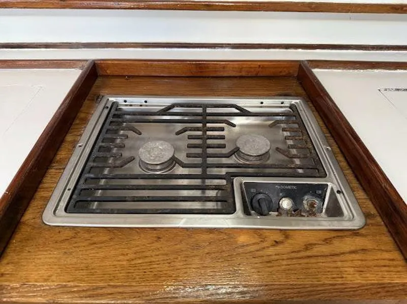 Slide: The Image of A built-in two-burner stove with wooden trim, surrounded by white surfaces. - 48