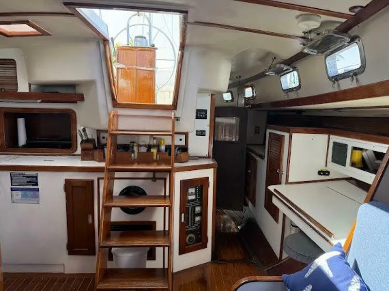 Slide: The Image of Interior of a sailboat with wooden floors, stairs, kitchen, and seating area. - 9
