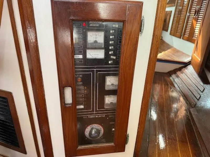 Slide: The Image of A wooden control panel with various switches and gauges on a boat. - 34