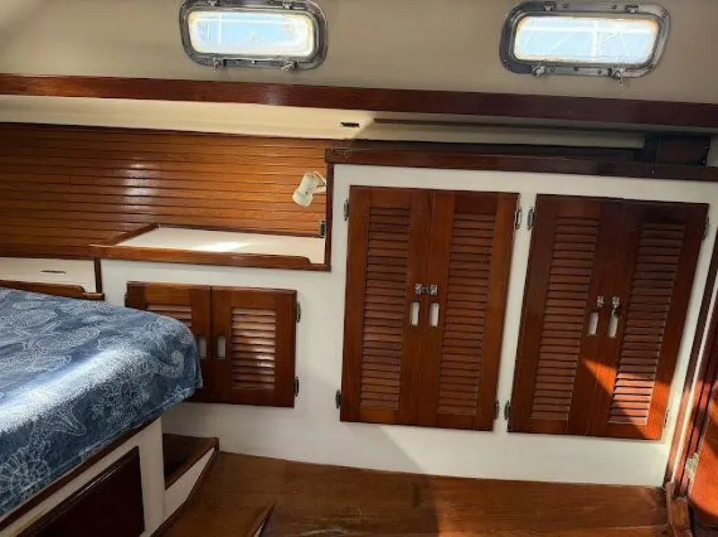 Slide: The Image of Interior of a 1989 Morgan 440 with wooden cabinetry and blue upholstery. - 29