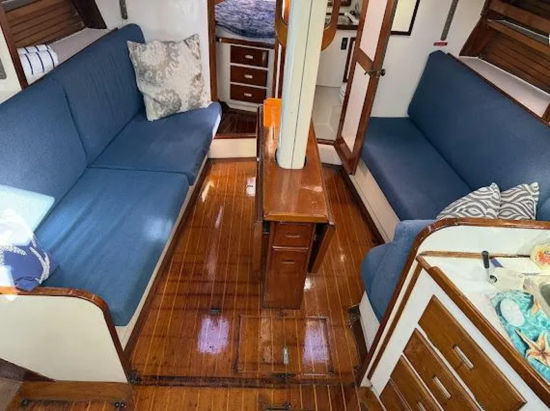Slide: The Image of Interior of a 1989 Morgan 440 with blue sofas and wooden flooring. - 4