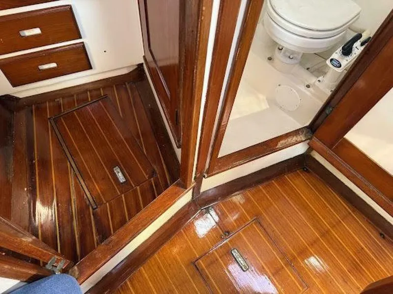 Slide: The Image of The interior features glossy wooden floors and a toilet in a well-maintained bathroom. - 11