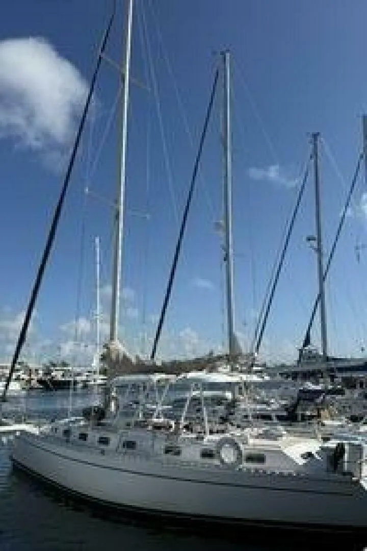 The Image of A 1989 Morgan 440 sailboat docked in a marina. The sky is clear and sunny. - 1