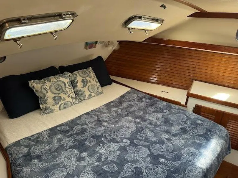 Slide: The Image of The image shows a cozy cabin with a double bed, decorative pillows, and wood paneling. - 19