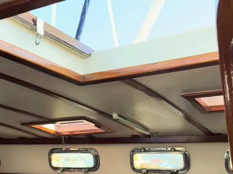Slide: The Image of Interior view of a boat with wooden accents and several windows in the ceiling area. - 6