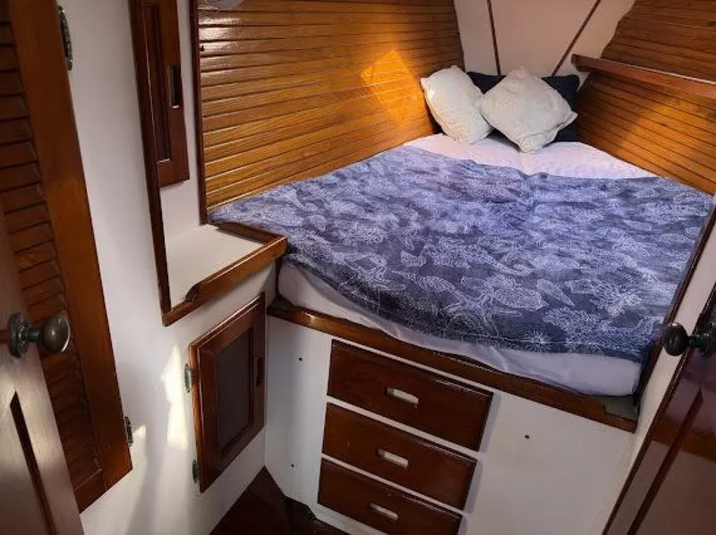 Slide: The Image of The cabin of a 1989 Morgan 440 with a cozy bed and wooden furnishings. - 14