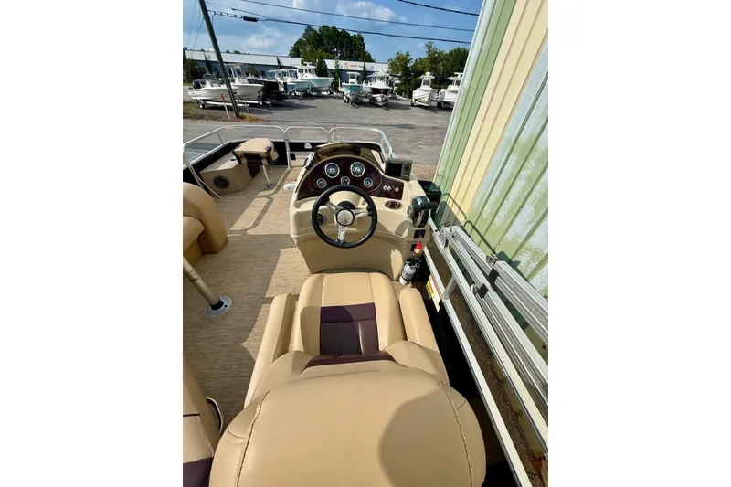 Slide: The Image of 2017 Lowe SF 214 Sport Fish boat interior with steering wheel and beige seating. - 7