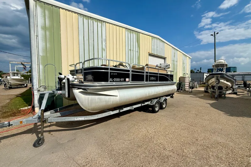 Slide: The Image of 2017 Lowe SF 214 Sport Fish boat on trailer, parked outside a warehouse. - 3