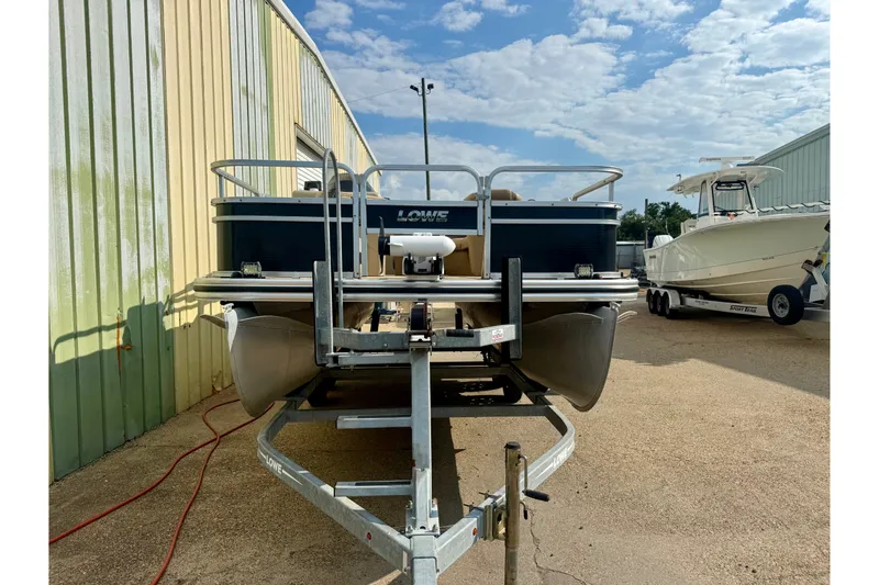 Slide: The Image of 2017 Lowe SF 214 Sport Fish boat on trailer, parked outdoors under a blue sky. - 4
